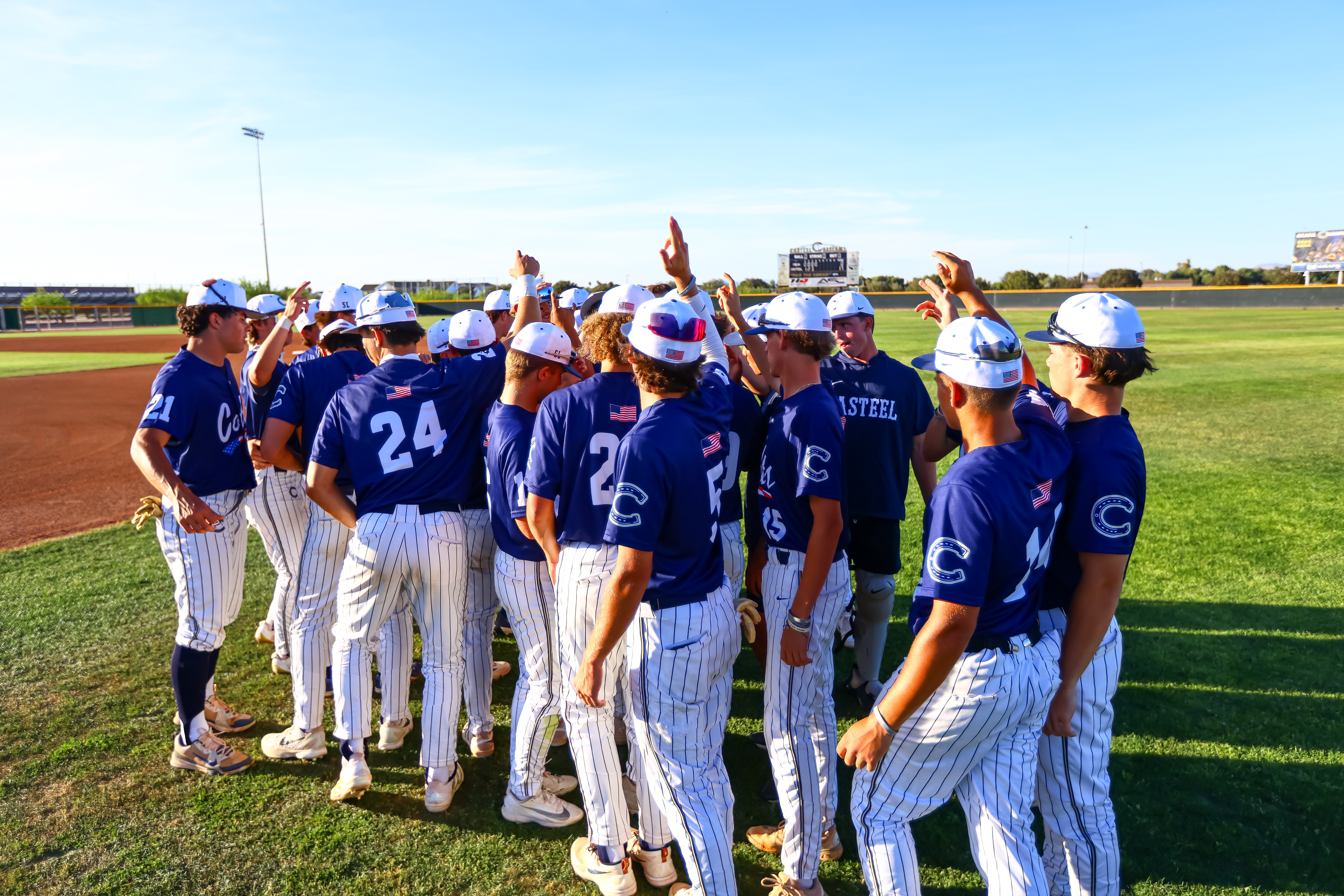 Casteel Baseball players gather in a team huddle on the field